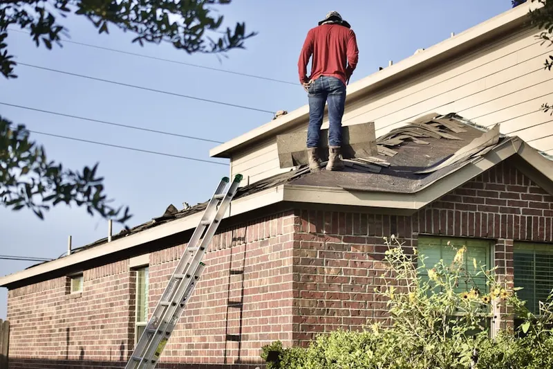 Professional roofer working on a residential roof in Portage